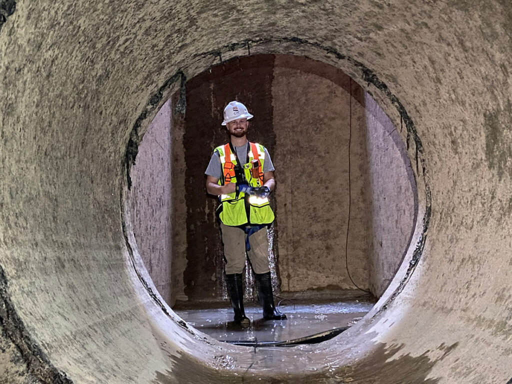 CAP employee standing in large pipe