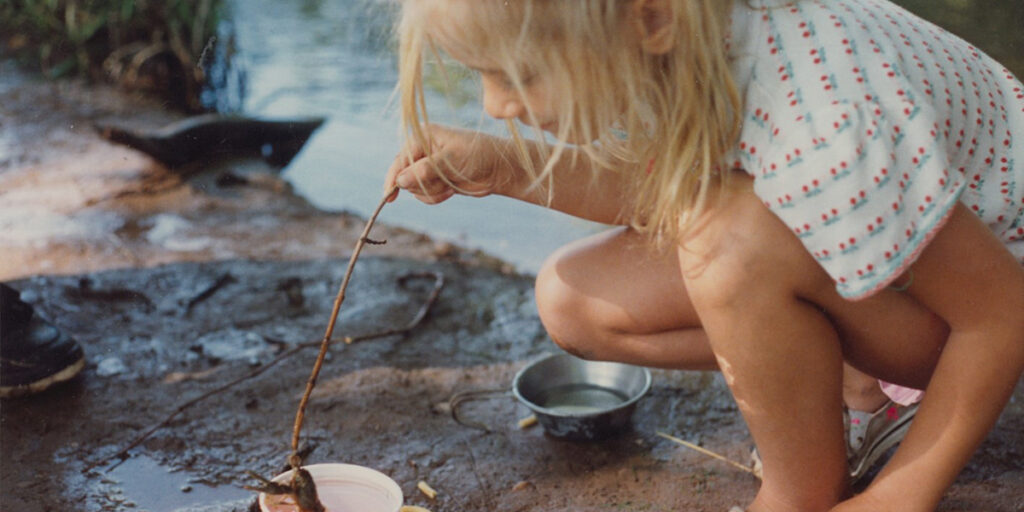 Natalie Mast as a child playing with a frog
