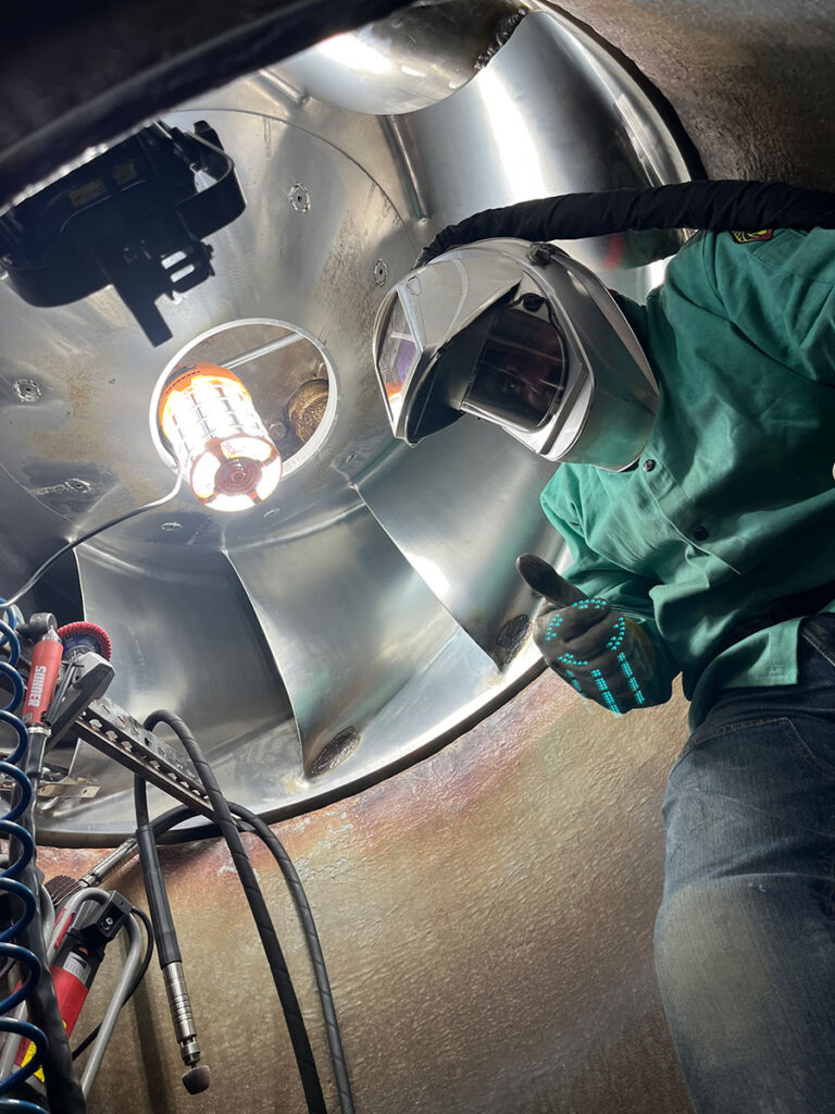 Mechanic working on pump with full safety gear