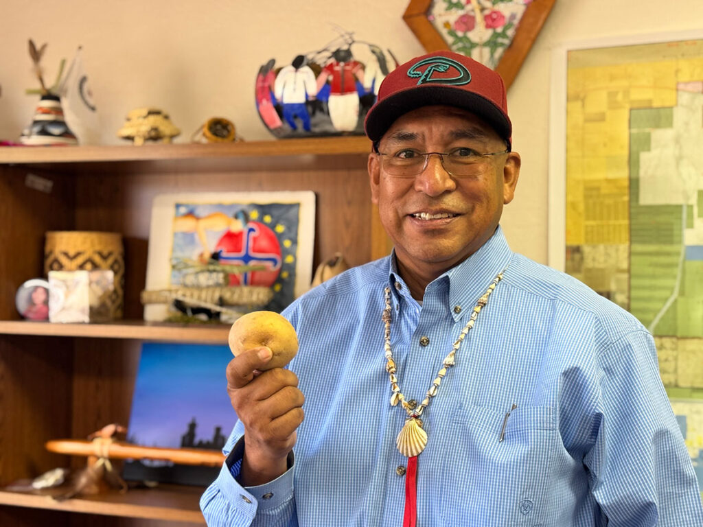 Ak-Chin Indian Community Chairman Gabriel Lopez holding a potato handpicked from the fields